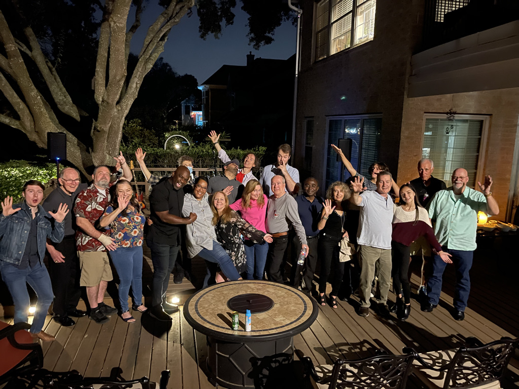 Group of friends waving on backyard deck