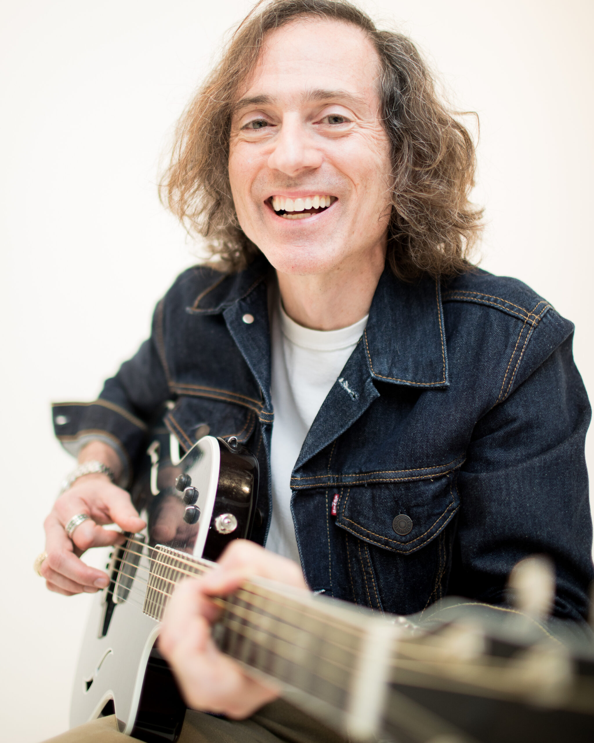 Smiling person playing electric guitar