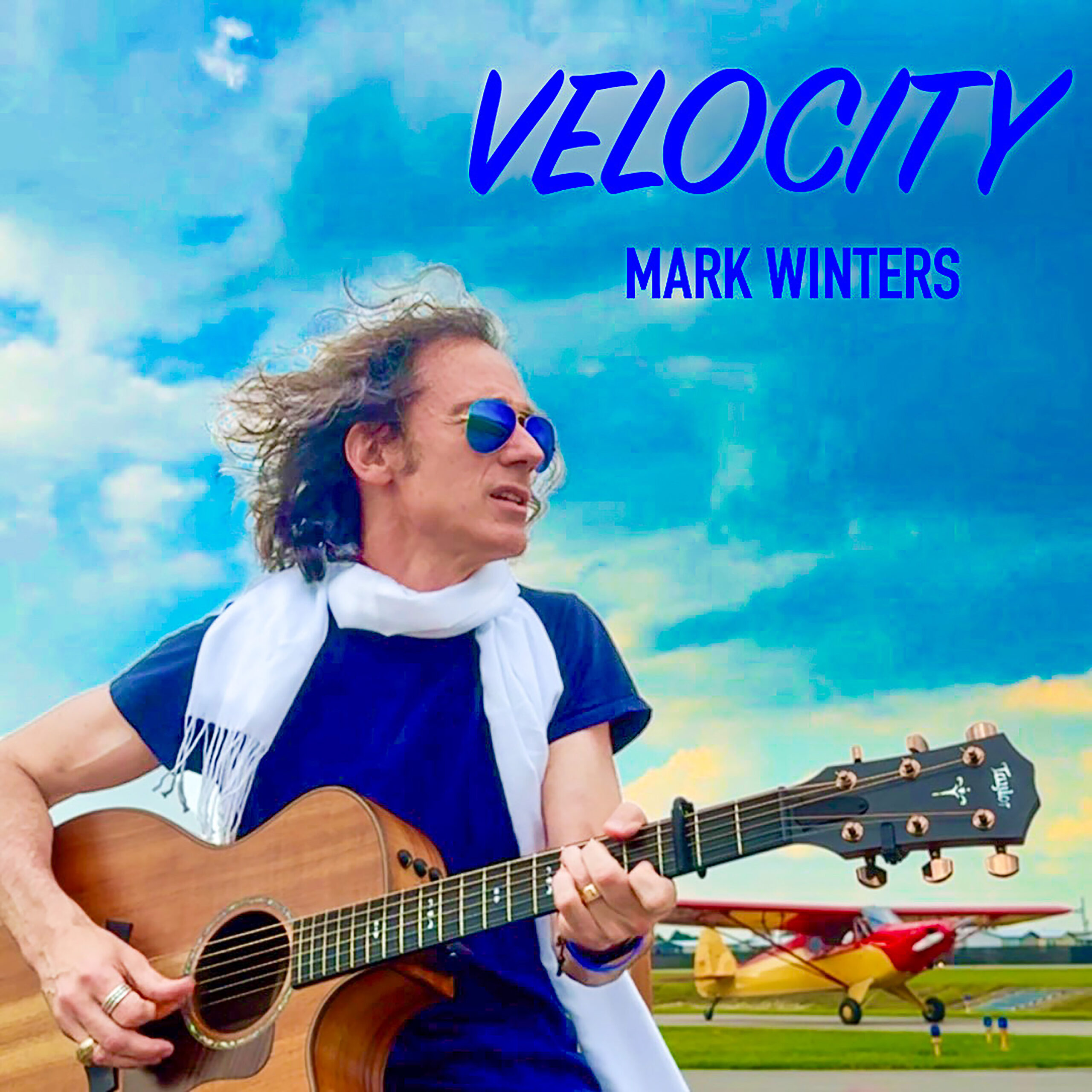 Guitarist outdoors with small airplanes and blue sky